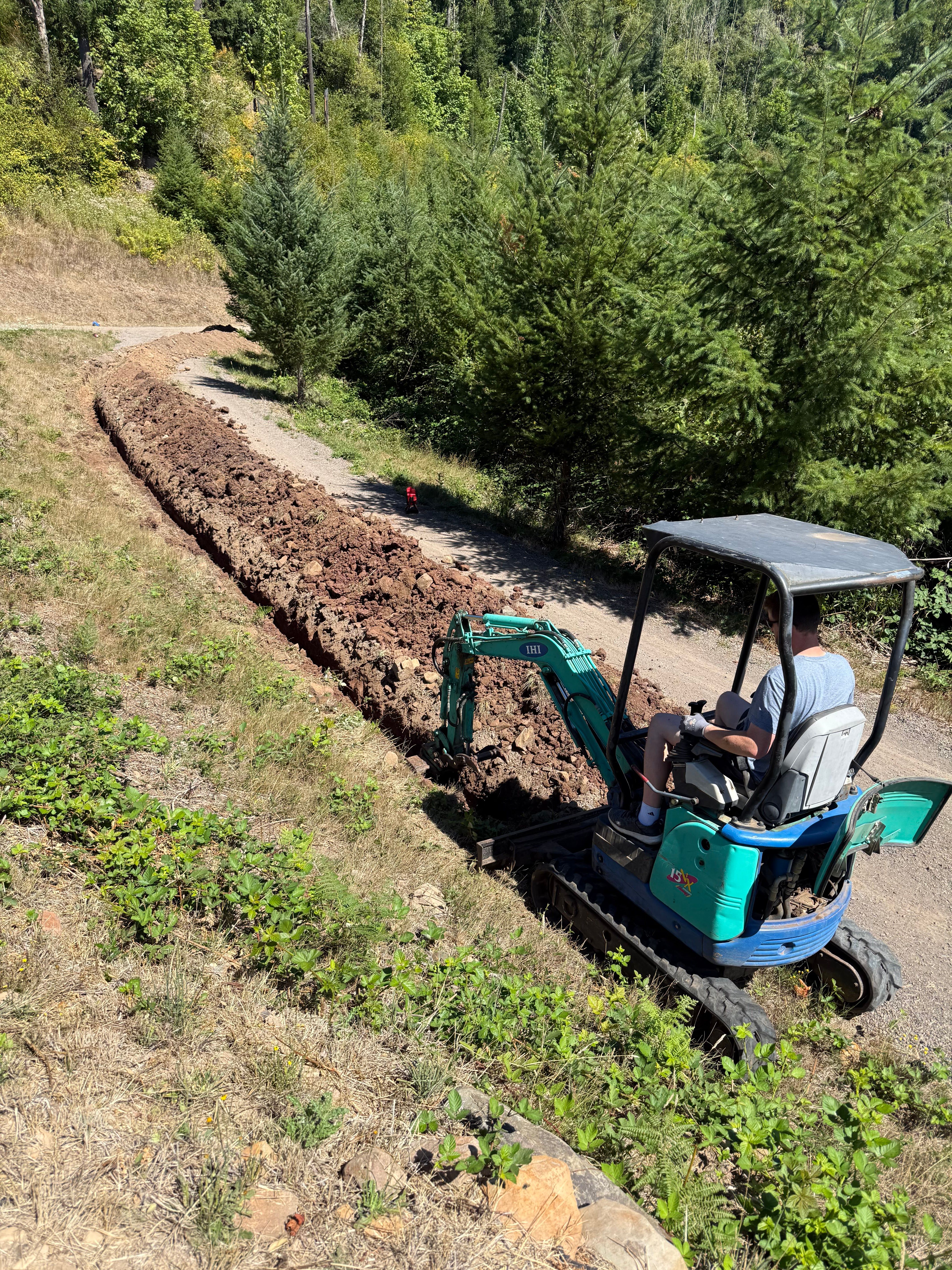 Excavator digging a trench for underground electrical conduit